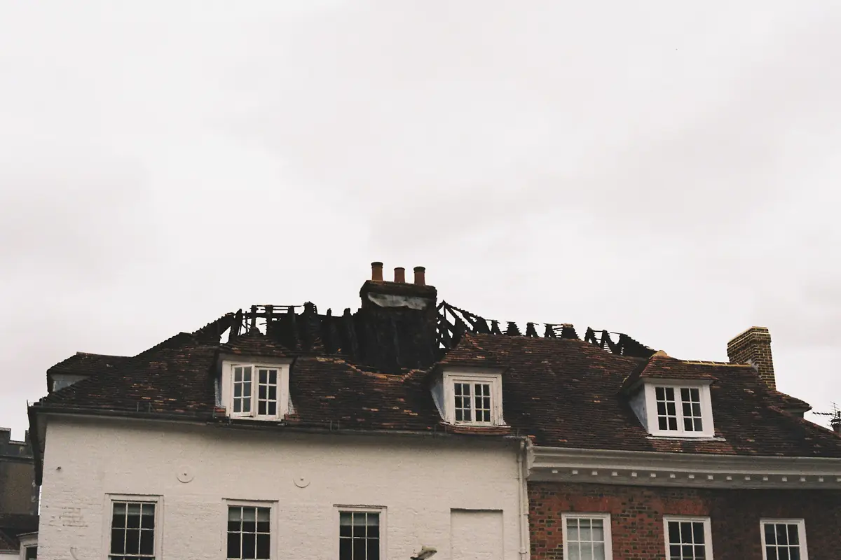 A house roof with charred beams after a fire